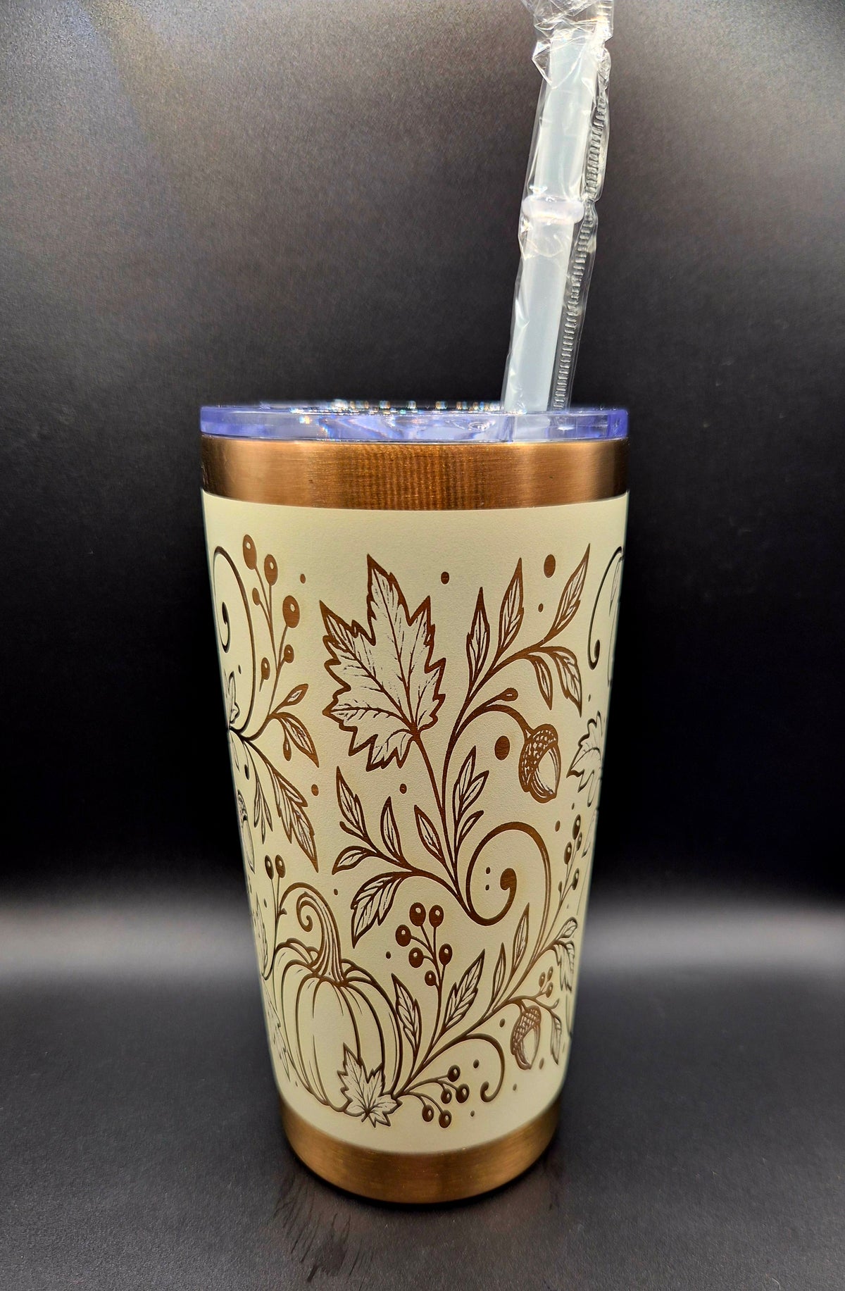 Cream stainless steel fall tumbler with copper laser-engraved pumpkins, swirling botanical vines, autumn leaves and acorns, with copper rim and base.