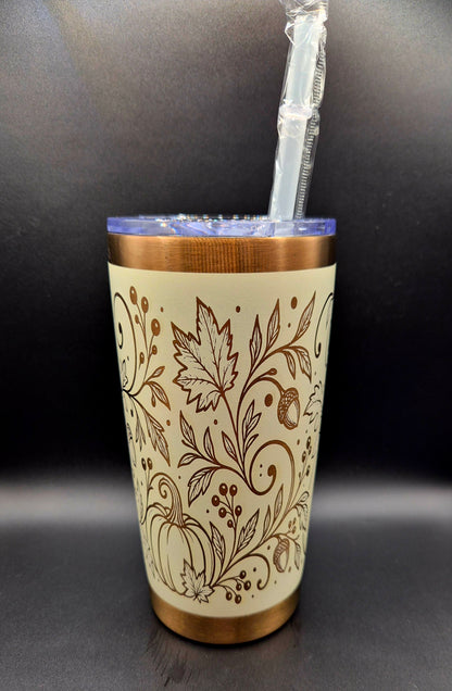 Cream stainless steel fall tumbler with copper laser-engraved pumpkins, swirling botanical vines, autumn leaves and acorns, with copper rim and base.