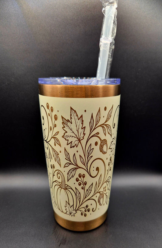 Cream stainless steel fall tumbler with copper laser-engraved pumpkins, swirling botanical vines, autumn leaves and acorns, with copper rim and base.
