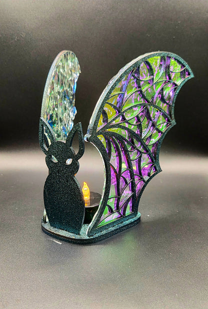 Handcrafted Halloween bat LED tealight holder with black bat silhouette, purple and green iridescent acrylic wings and a glowing tealight.