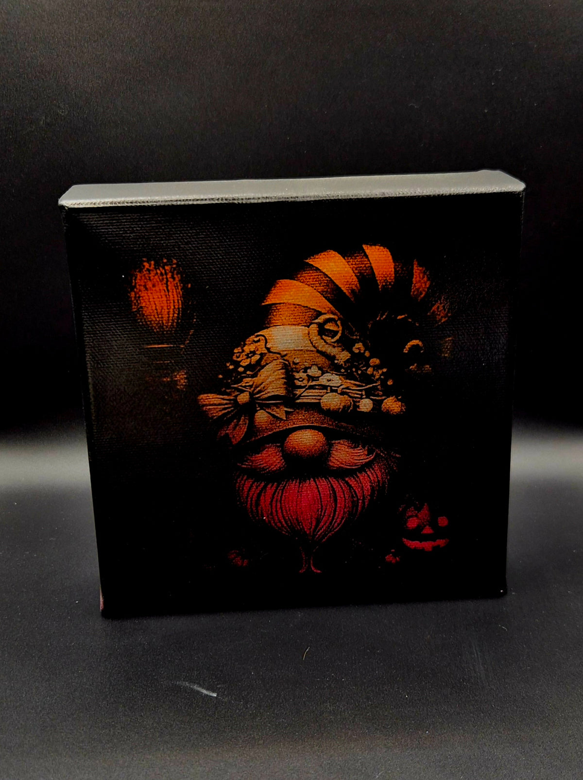 Hand-painted and laser-engraved fall gnome mini canvas with orange and burgundy tones, seasonal hat, pumpkins and rustic autumn details on black.