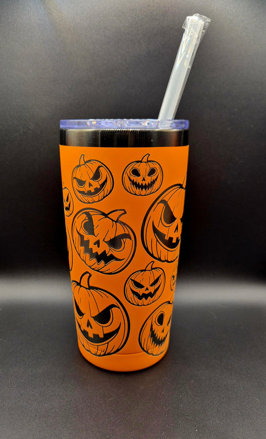 Bright orange stainless steel Halloween tumbler with black laser-engraved jack-o'-lantern faces in assorted sizes and expressions.